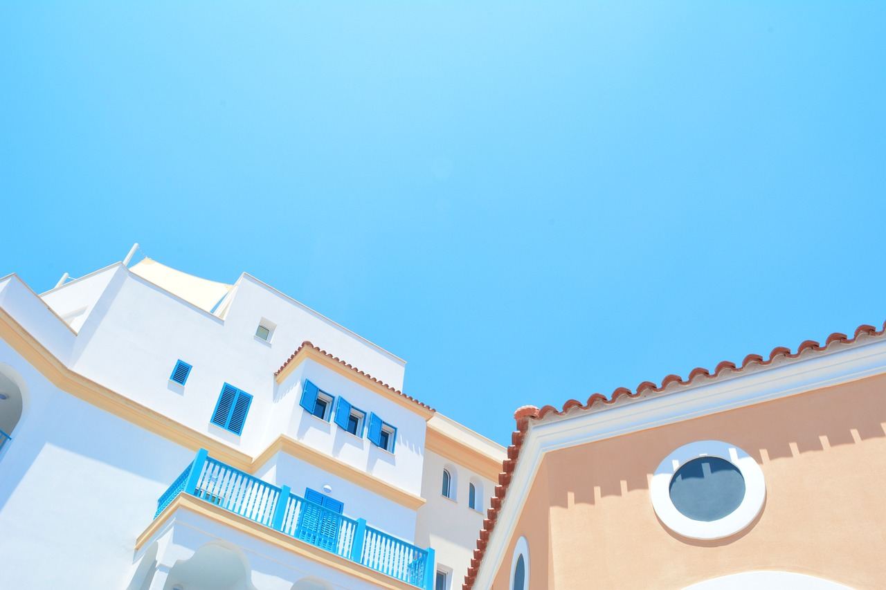 Fachada mediterránea en tonos pastel con carpintería azul