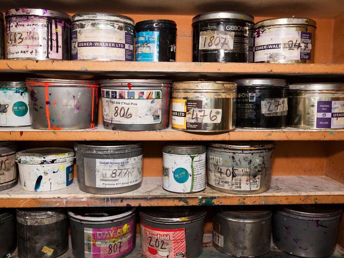 Estantería con botes de pintura de distintos colores mezclados